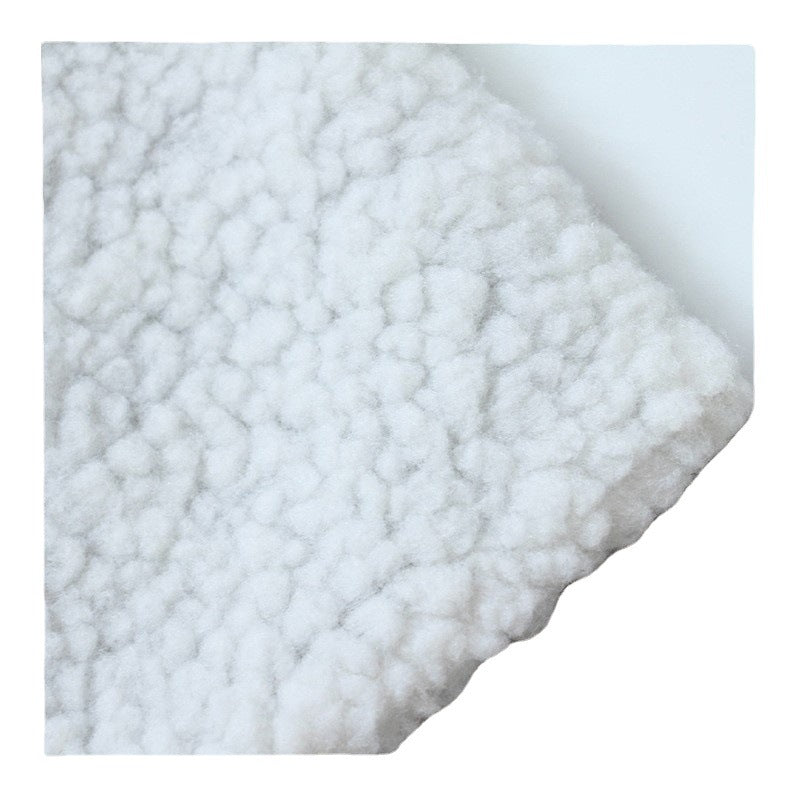 Close-up of the plush white sherpa fleece corner of the dog kennel mat showing its soft deep-pile texture