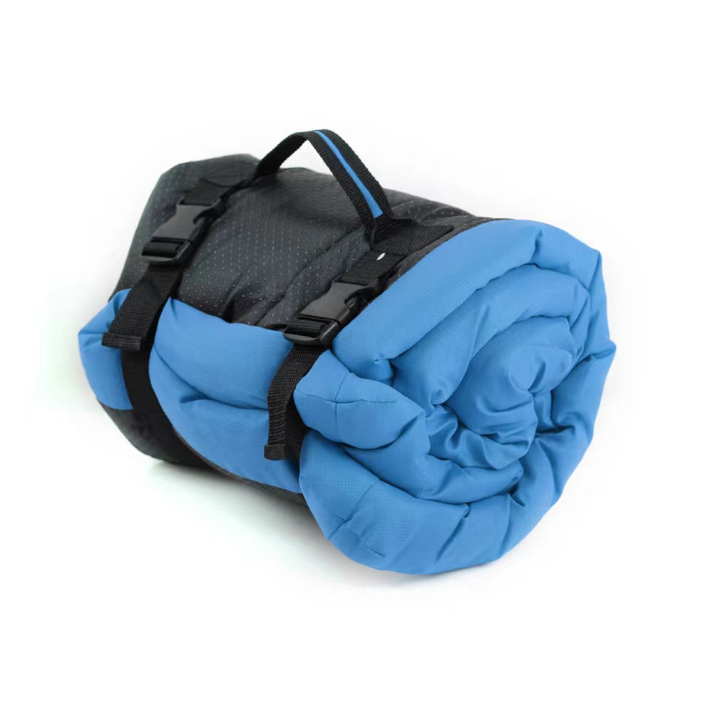 Side view of the blue roll-up dog bed packed into its compact roll with black buckle straps and a top carry handle, on a white background.
