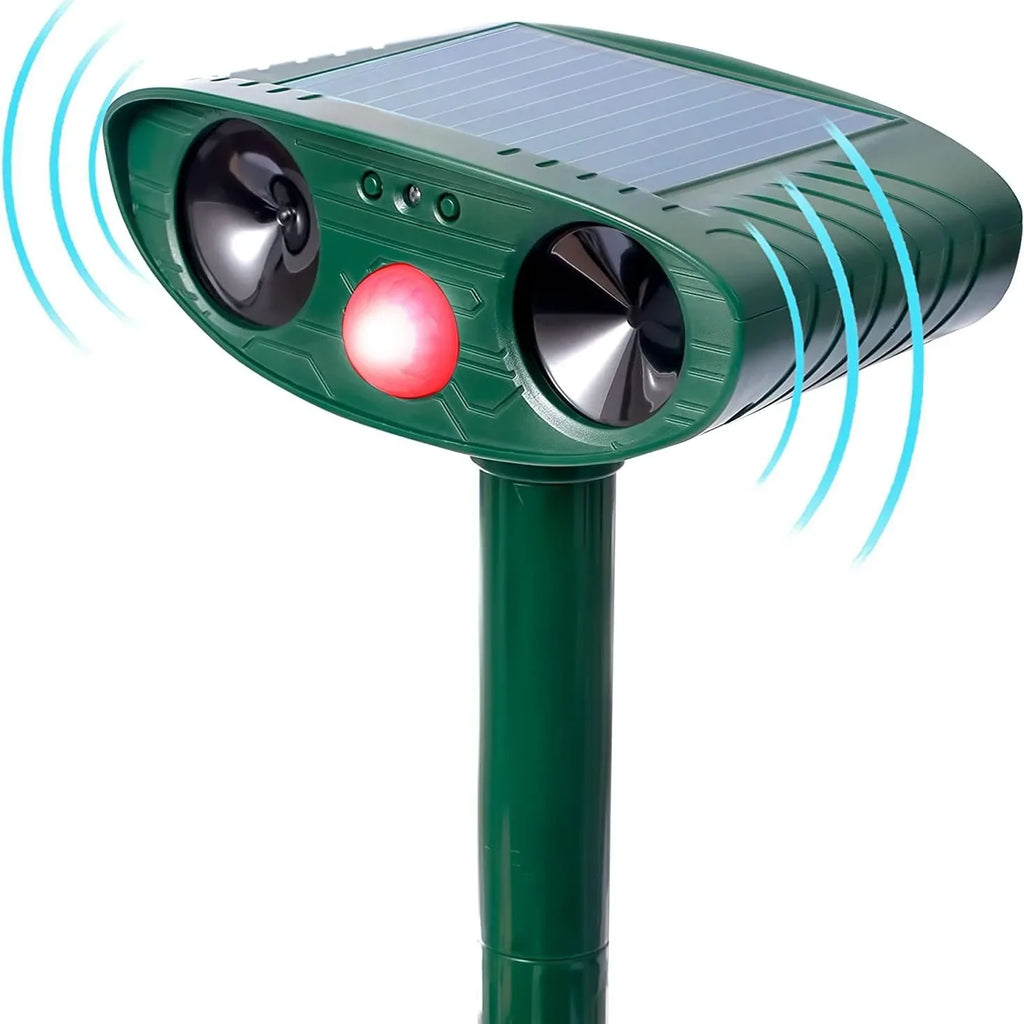 Close-up of the green solar repellent head with its two dark speaker cones, glowing red motion-sensor light, and blue ultrasonic waves radiating from each side.