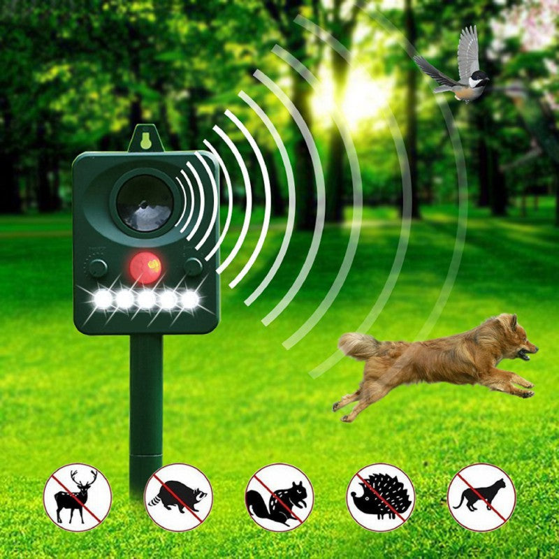 Green solar repellent in a sunny park scaring off a flying bird and a running dog with ultrasonic waves, above crossed-out icons of a deer, raccoon, cat, hedgehog, and dog.