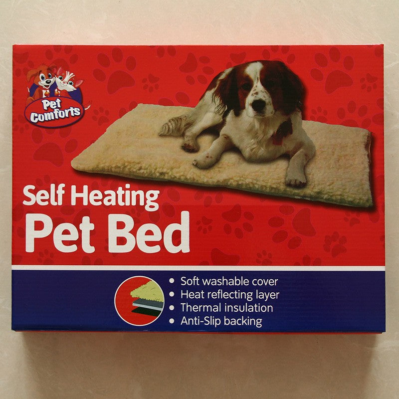 Self-heating dog kennel mat shown in retail packaging with a spaniel resting on the tan cushioned pad